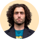 man with long curly hair and a blue shirt