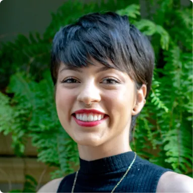 smiling woman with short black hair and a black turtle neck top posing for the picture