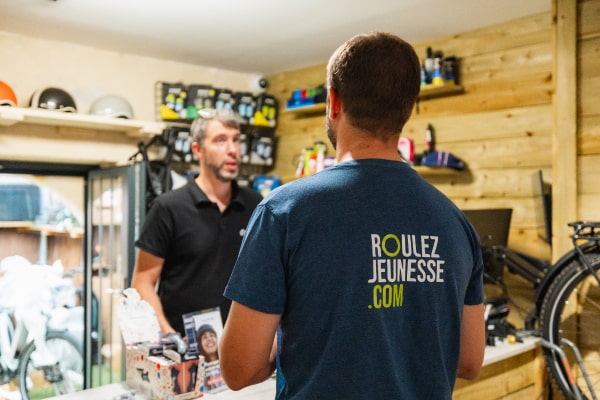 Photo d'un représentant Roulez Jeunesse discutant avec une professionnel du vélo