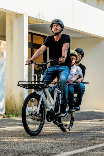 Photo d'un papa à vélo longtail avec ses enfants 