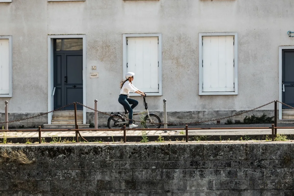 Cycliste casquee roulant a velo le long du quai de La Rochelle