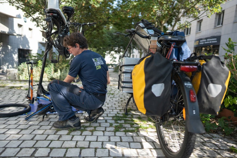 Réparateur Roulez Jeunesse à vélo cargo dans une rue de Bordeaux
