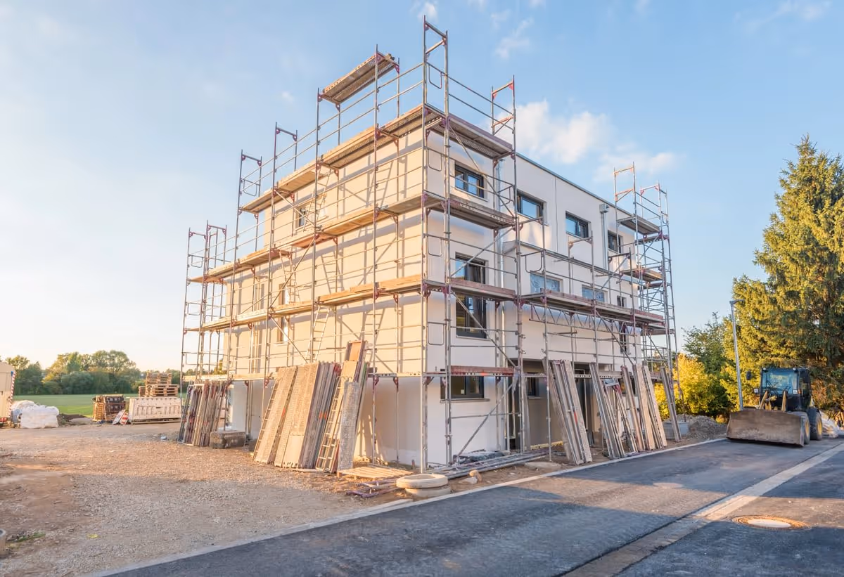 Baustelle eines Mehrfamilienhauses mit Gerüst, im Rohbau