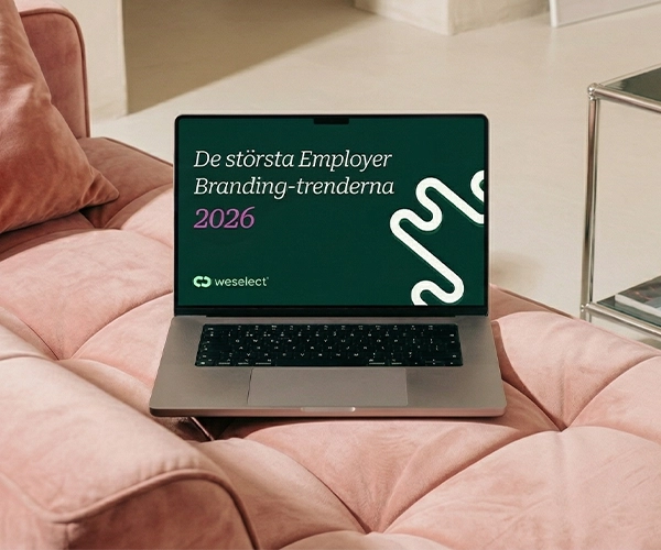 Laptop på en rosa soffa som visar omslaget till weselects e-bok "The Biggest Employer Branding Trends of 2026."