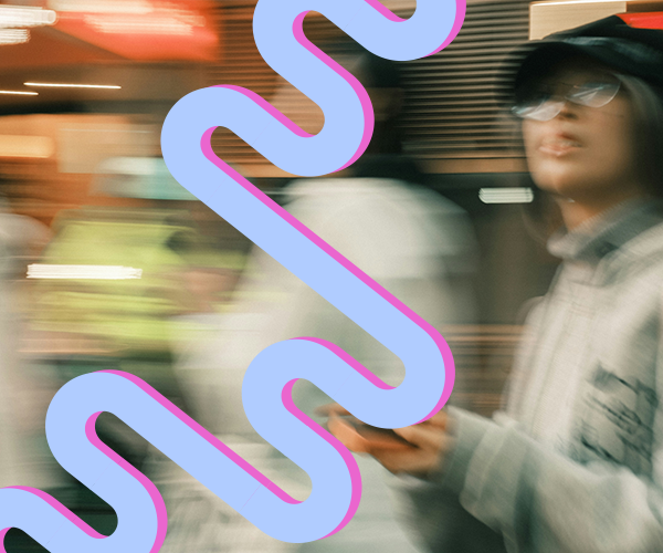 Blurred shot of people in motion, one holding a phone, with blue and pink wavy shapes laid over the image.
