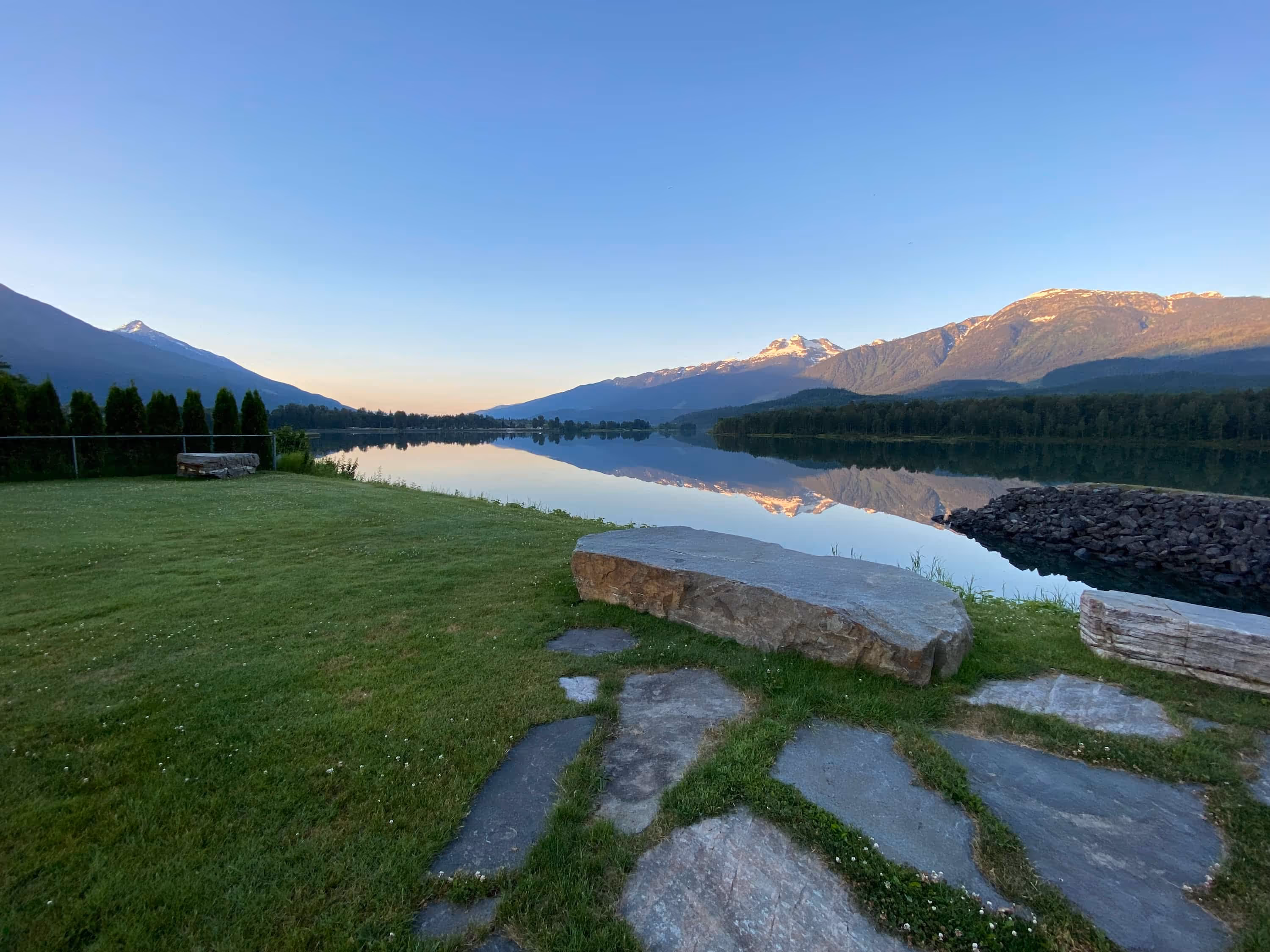 Grass, river and mountains at sunset.