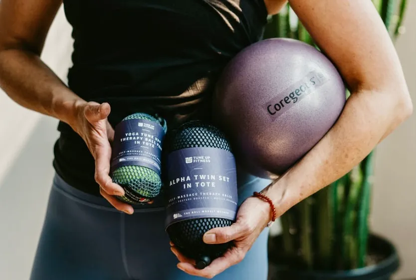 Person holding 3 sets of Yoga Tune Up fitness balls.