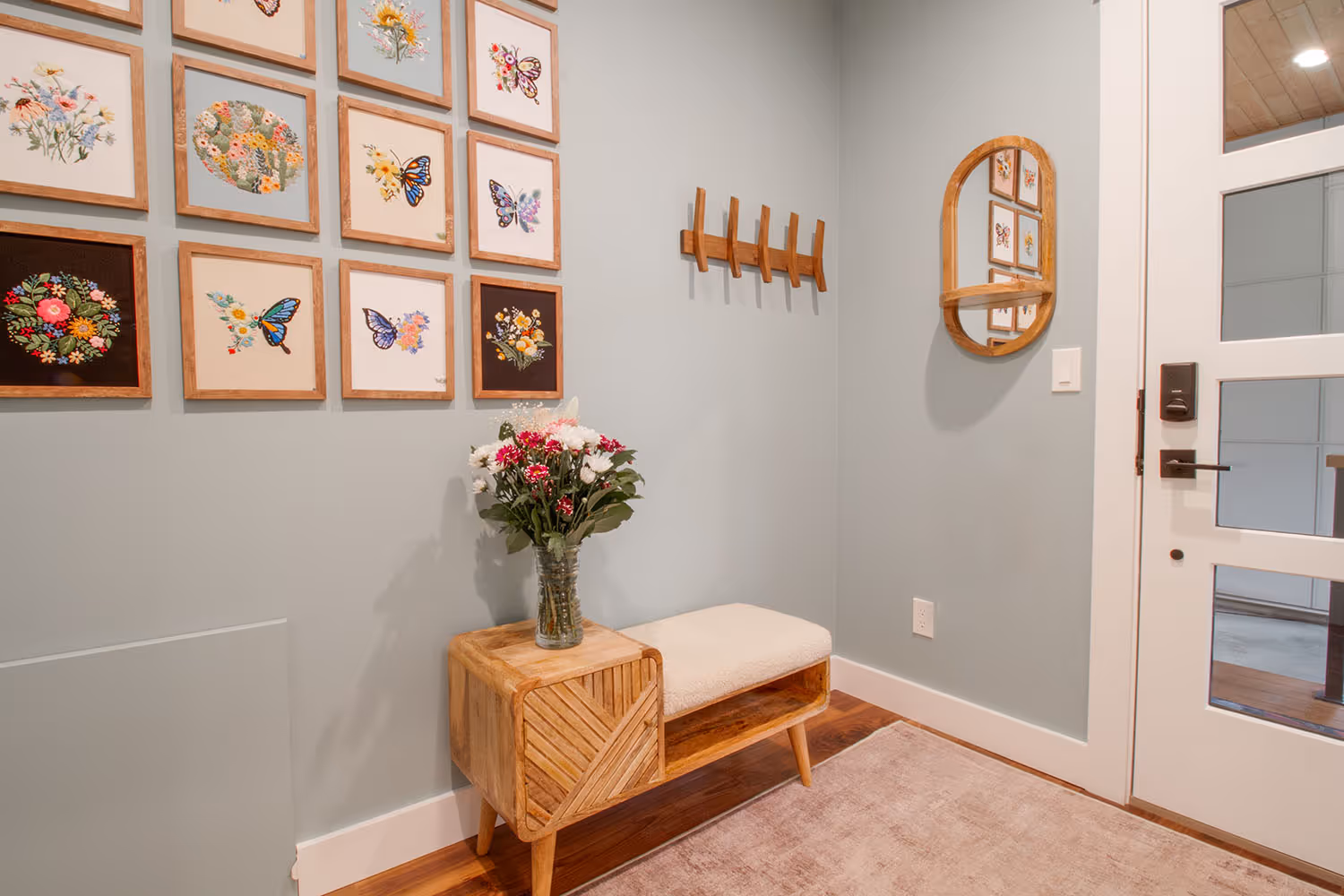 Door and entryway, with hooks and artwork on the wall.