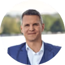 Ich weiß nicht, wer das ist. Geschäftsmann im blauen Anzug vor unscharfem Hintergrund mit Bäumen.