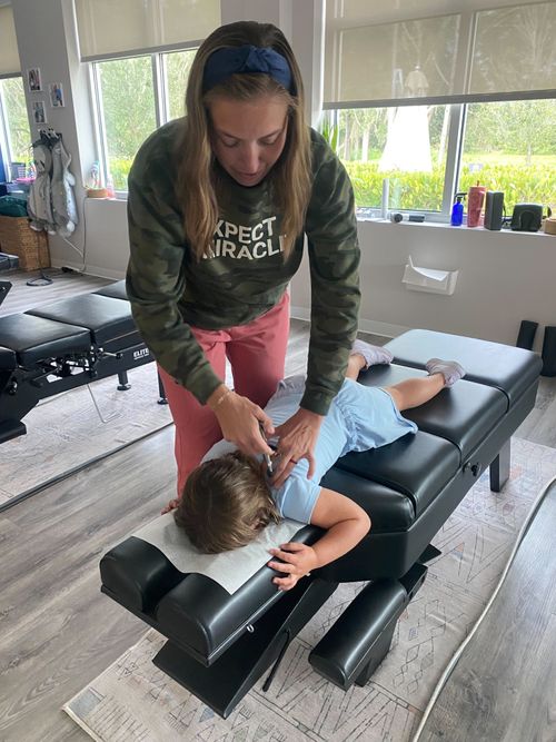A neurologically focused chiropractor adjusts a young girl.
