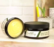 Natural eczema balm and soap on a towel beside a child’s hand with healing skin