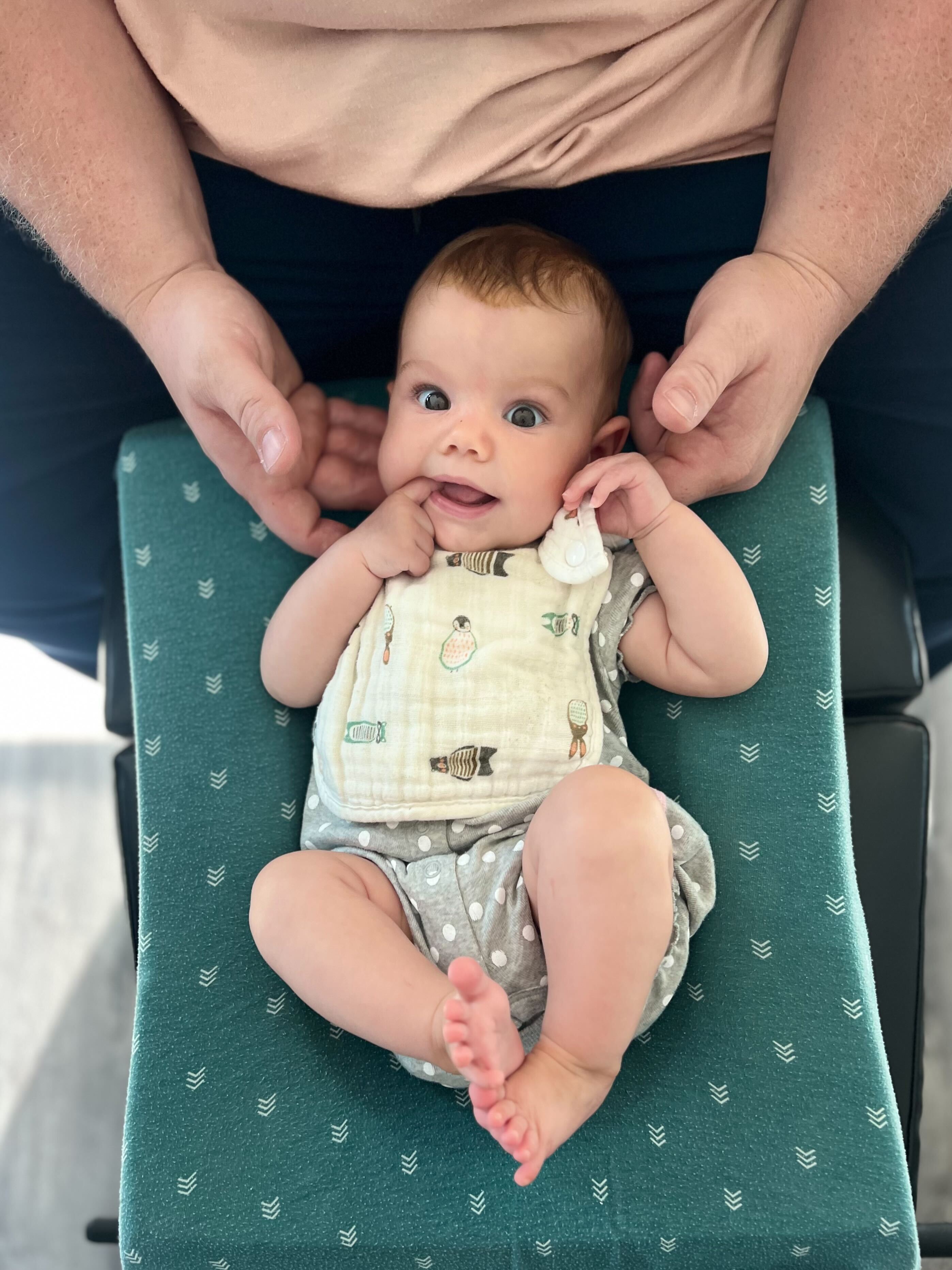 Pediatric chiropractor in Sarasota demonstrating a nervous system based adjustment on an infant.