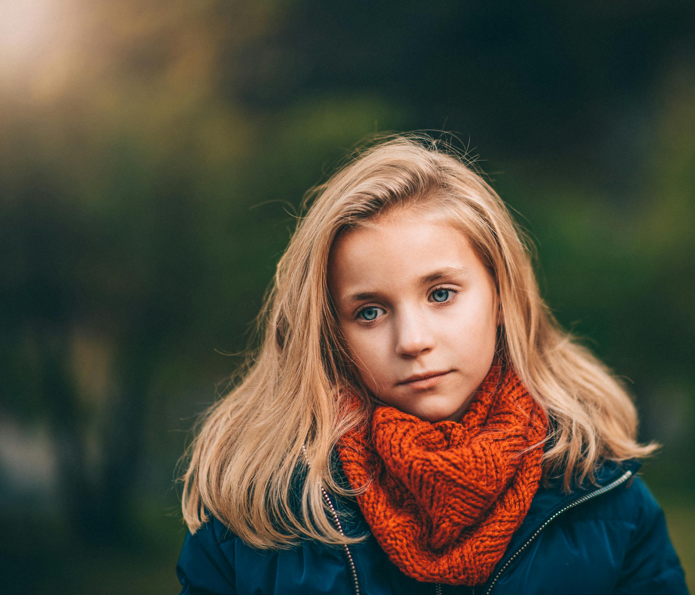 Child wrapped in scarf smiling during cold season