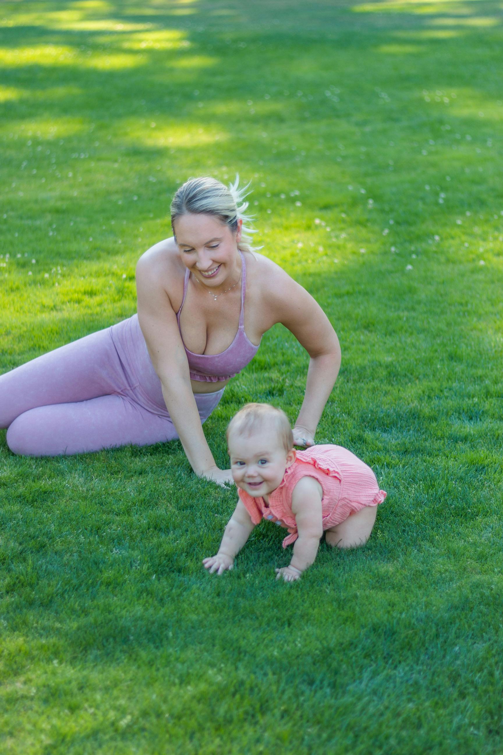 Baby practicing crawling outside with mom