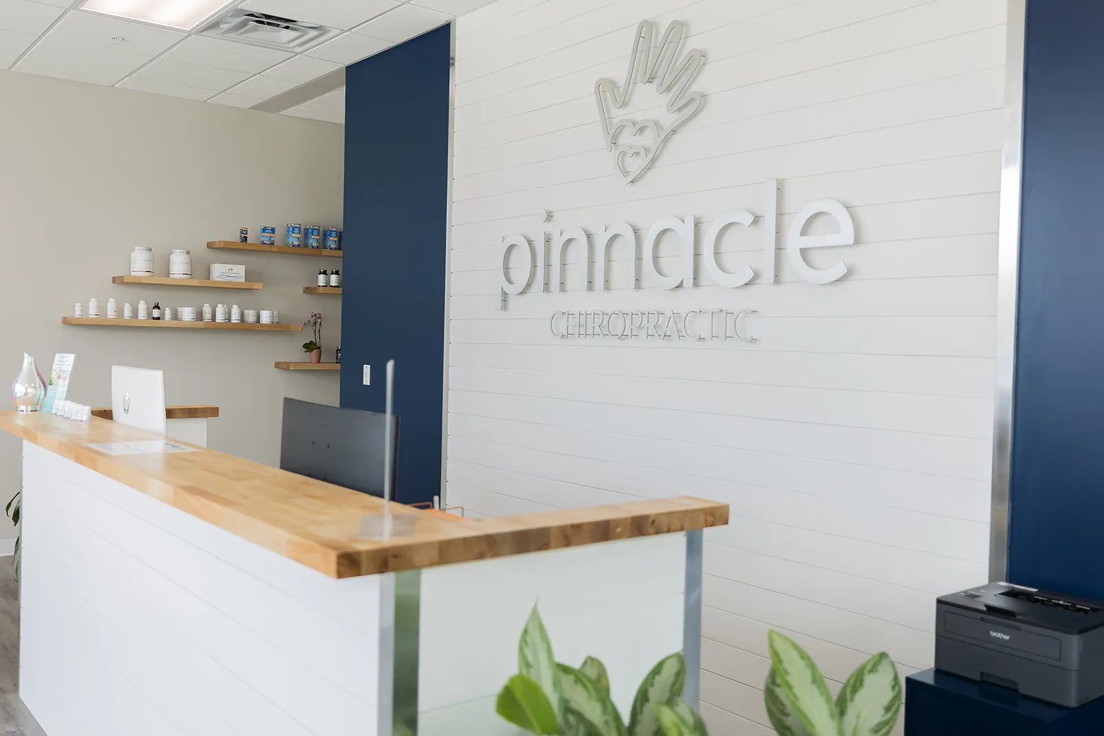 The Pinnacle Chiropractic front desk with shelves of wellness products