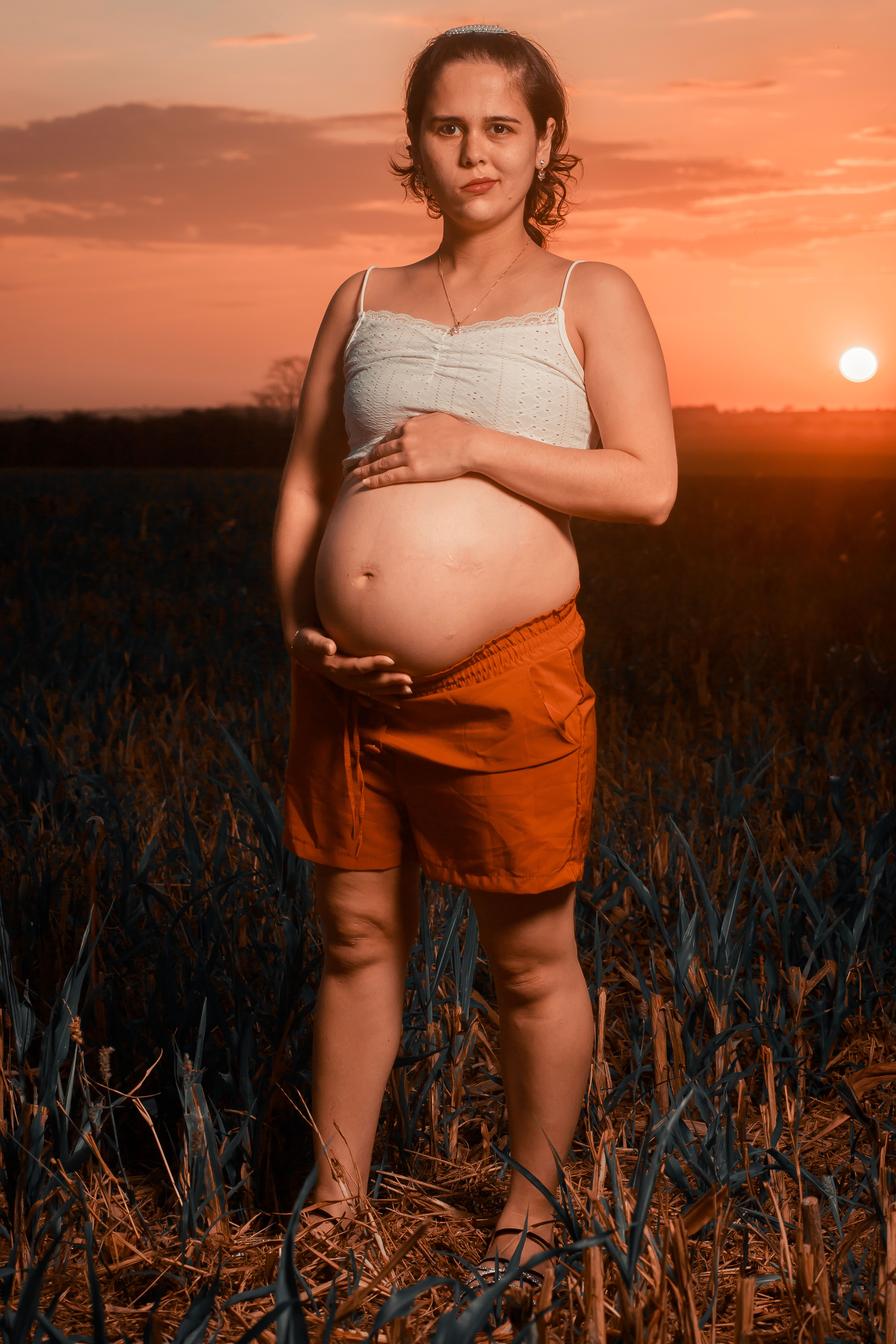 Pregnant woman posing with sunset in the background