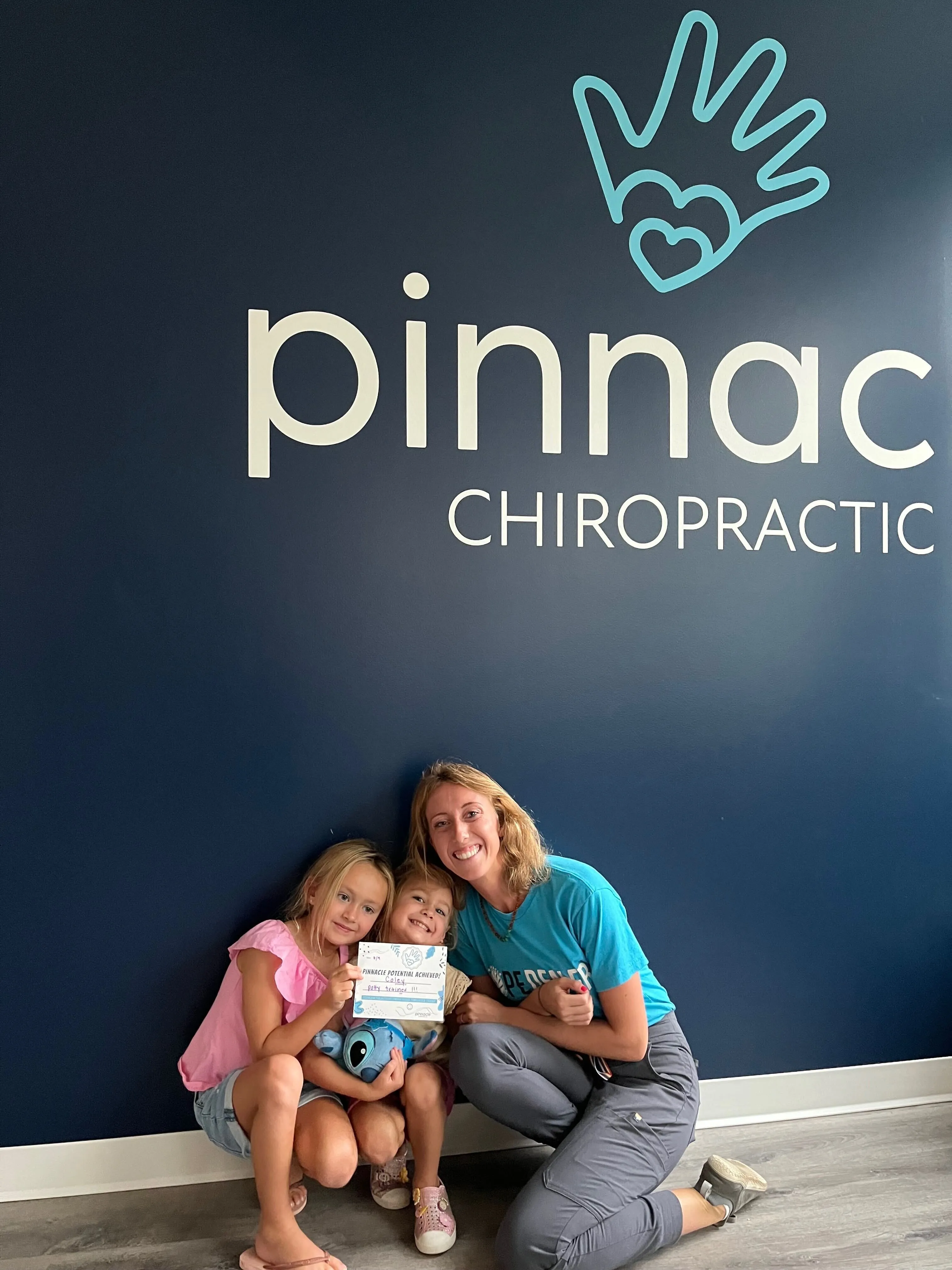 Pinnacle Chiropractic team members with two girls in the office
