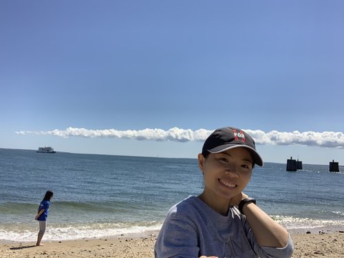 Jenny Lin smiling at the beach on a sunny day