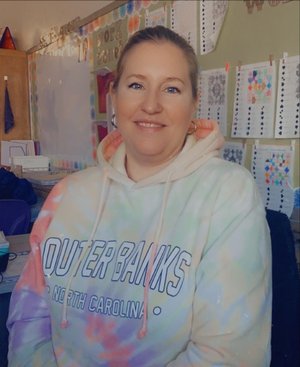 Dena Martin smiling in a colorful classroom setting
