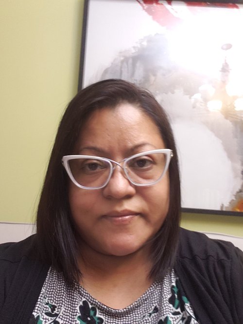Staff member Taskin Raybin wearing white-framed glasses