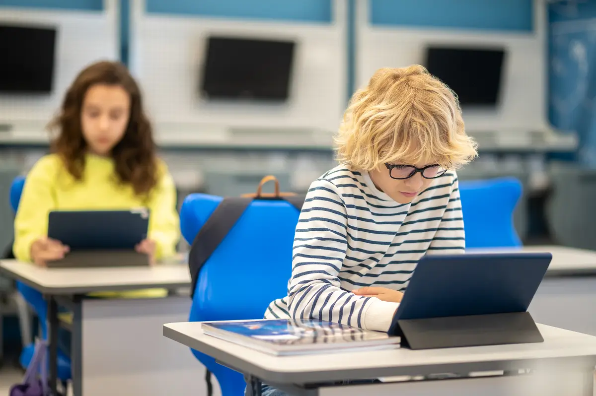 a boy student using tech devices in class