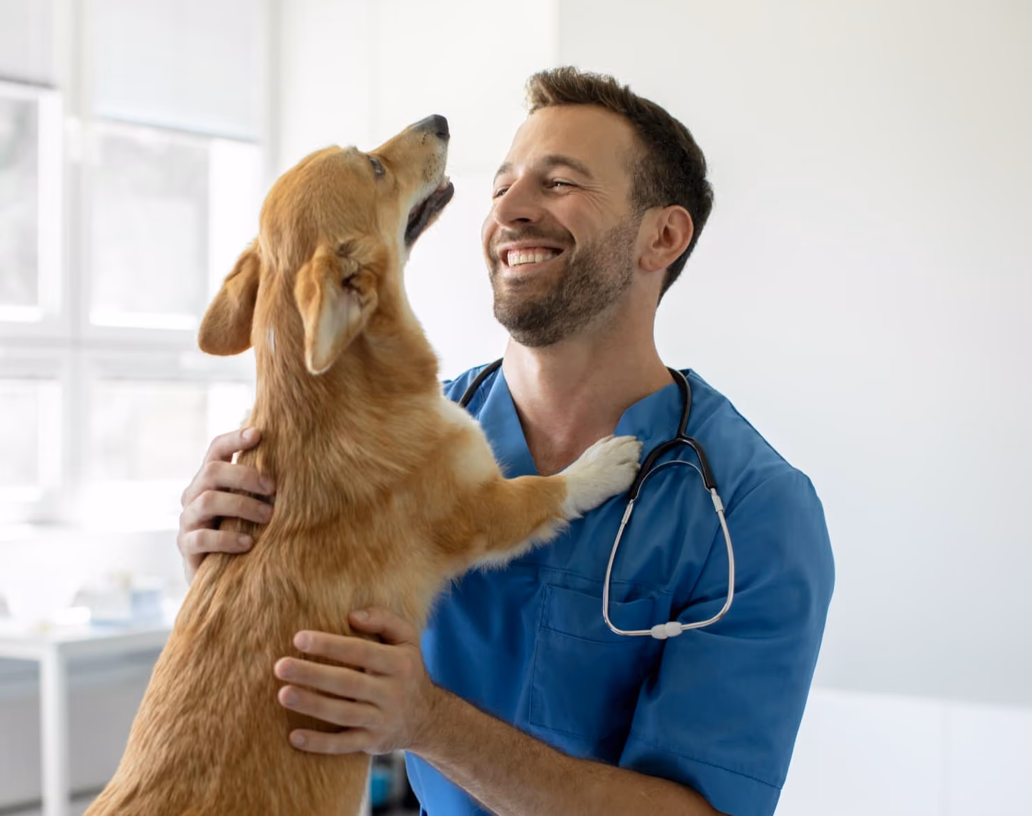 a man in scrubs holding a dog in his arms