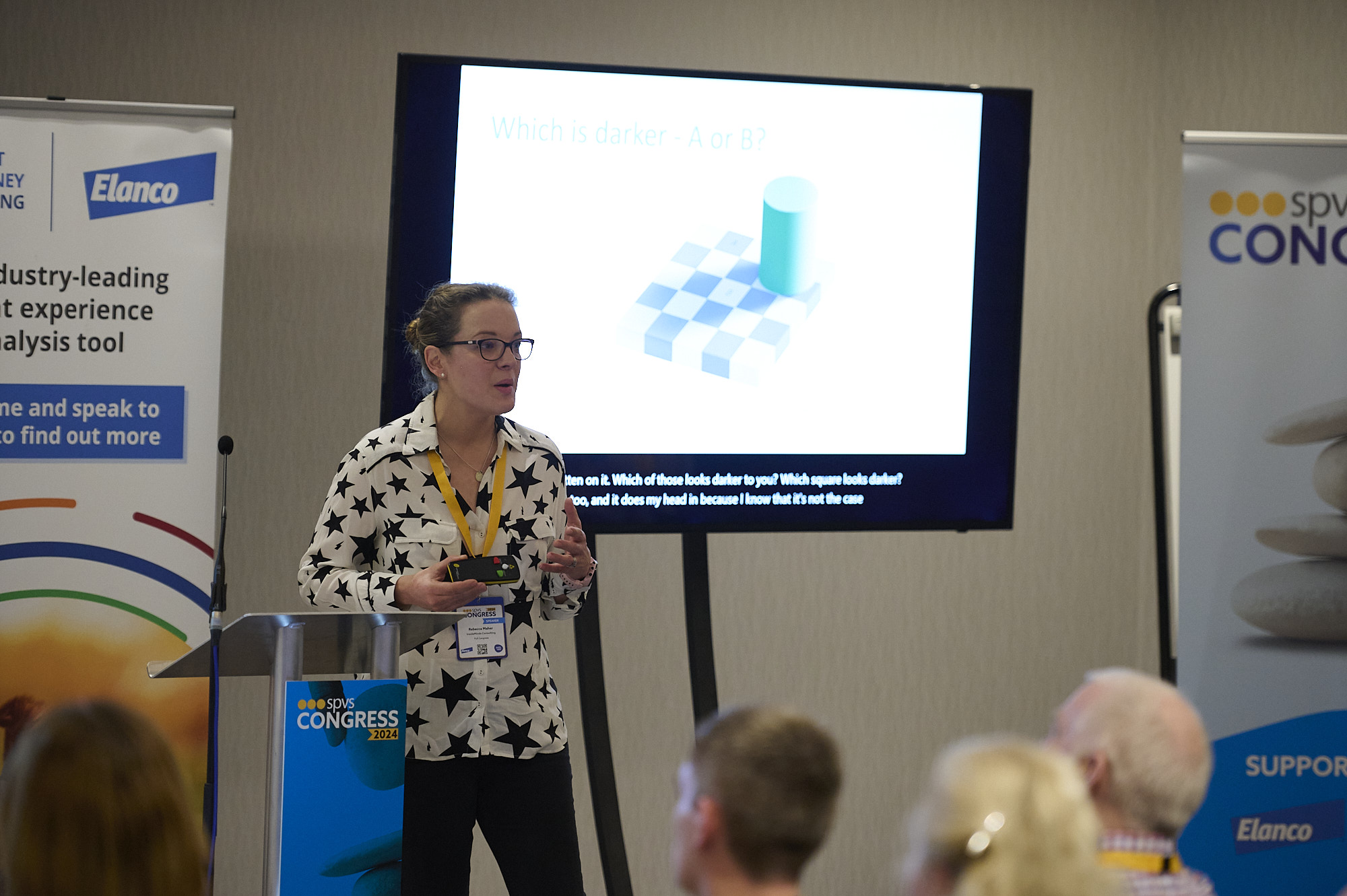Woman in star-patterned shirt giving a presentation at SPVS Congress 2024 with a visual illusion slide.