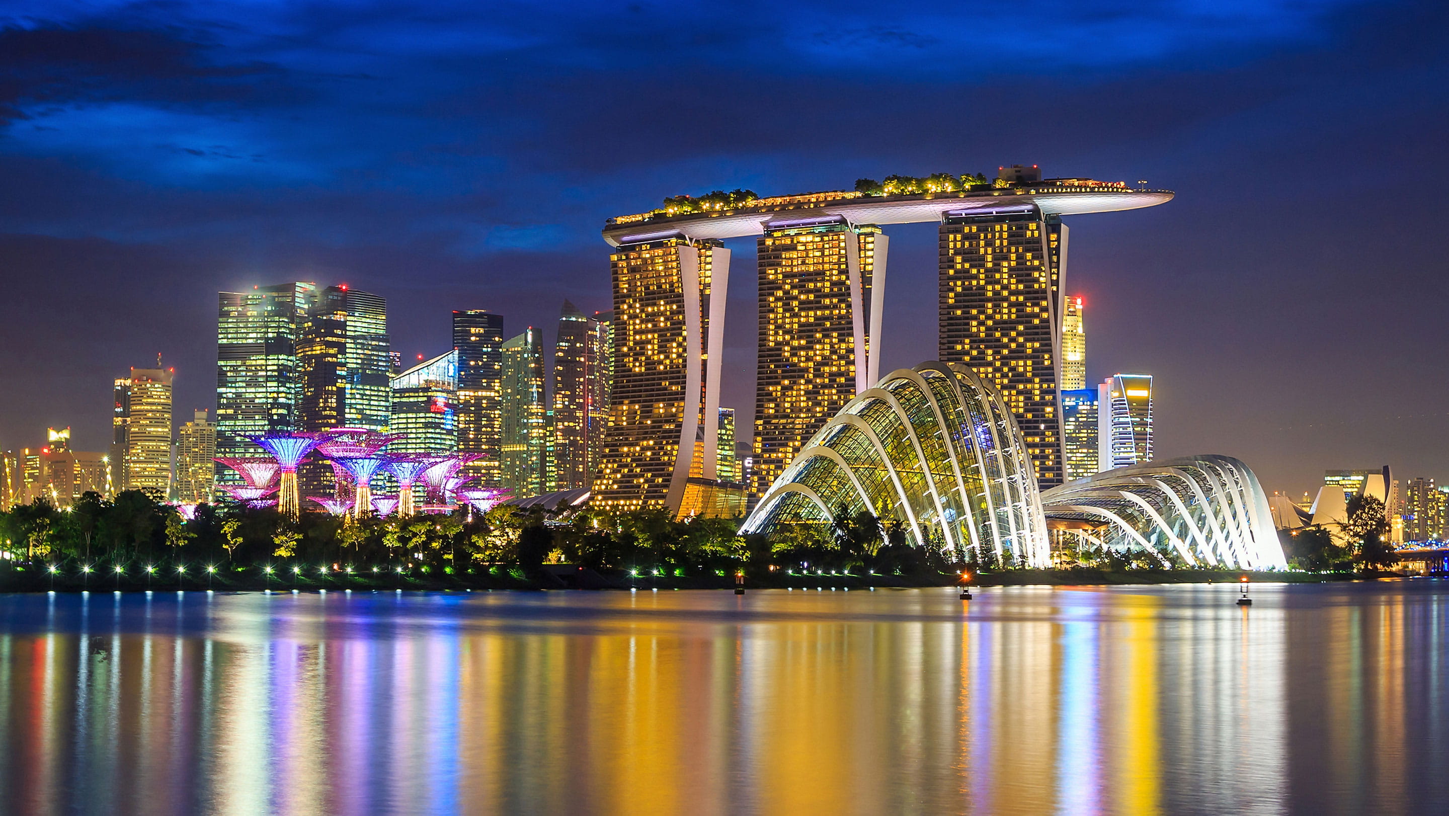 Singapore skyline at night featuring Marina Bay Sands and Gardens by the Bay, representing Singapore’s financial hub and asset management industry.