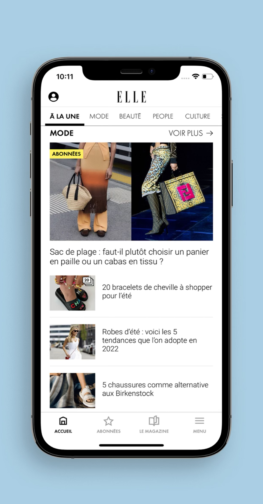  l’application mobile ELLE sur smartphone. L’écran affiche la section "Mode" avec plusieurs articles : un comparatif entre panier de plage en paille et cabas en tissu, un article sur les bracelets de cheville, les tendances robes d’été 2022, et une sélection de chaussures alternatives aux Birkenstock. En bas de l’écran, le menu de navigation comprend les onglets Accueil, Abonnées, Le Magazine et Menu.