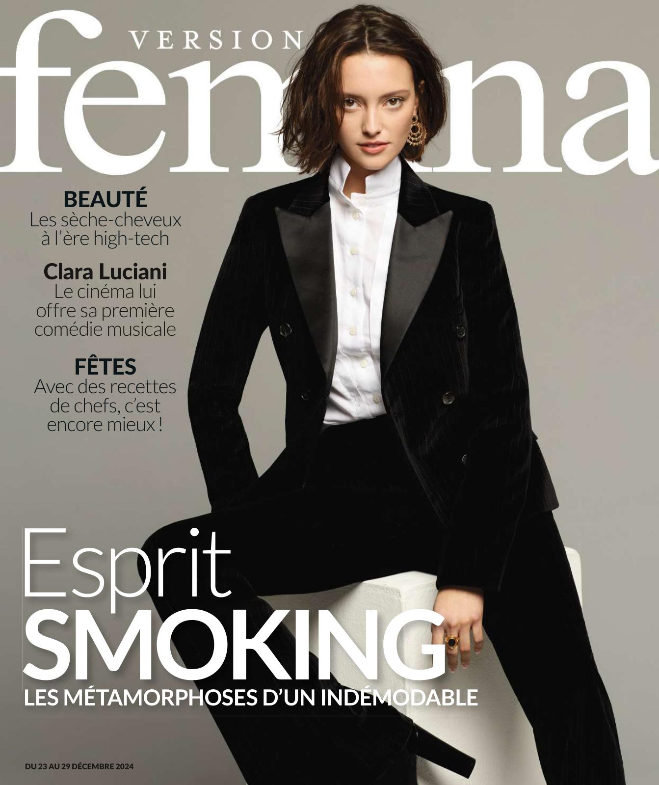 Une femme brune en smoking noir est assise sur un tabouret blanc. Elle porte une chemise blanche et des boucles d’oreilles dorées. Le titre principal dit : "Esprit SMOKING – Les métamorphoses d’un indémodable".