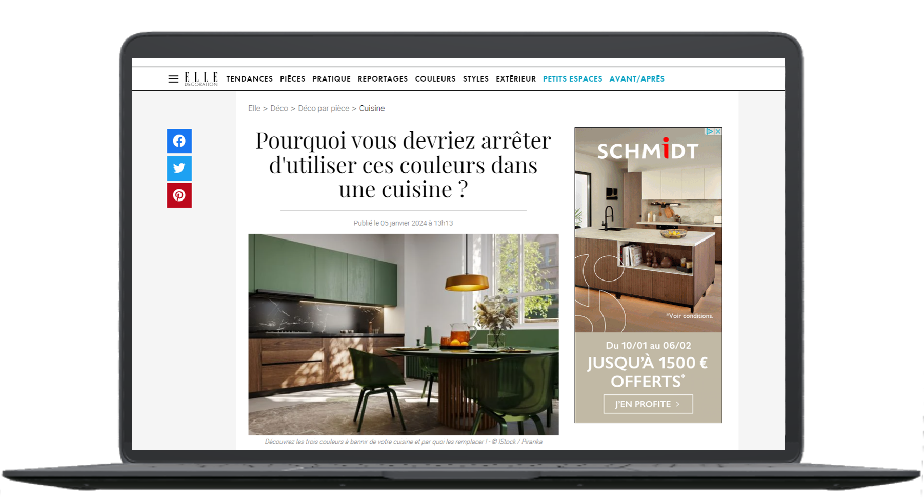  Capture d’écran d’un article du site ELLE Décoration intitulé « Pourquoi vous devriez arrêter d’utiliser ces couleurs dans une cuisine ? ». L’image montre une cuisine design avec des meubles bas en bois foncé, des placards vert sauge et un mur blanc. Une lampe suspendue jaune et une table ronde entourée de chaises vertes complètent la scène. Une publicité pour la marque Schmidt apparaît à droite de l’écran.