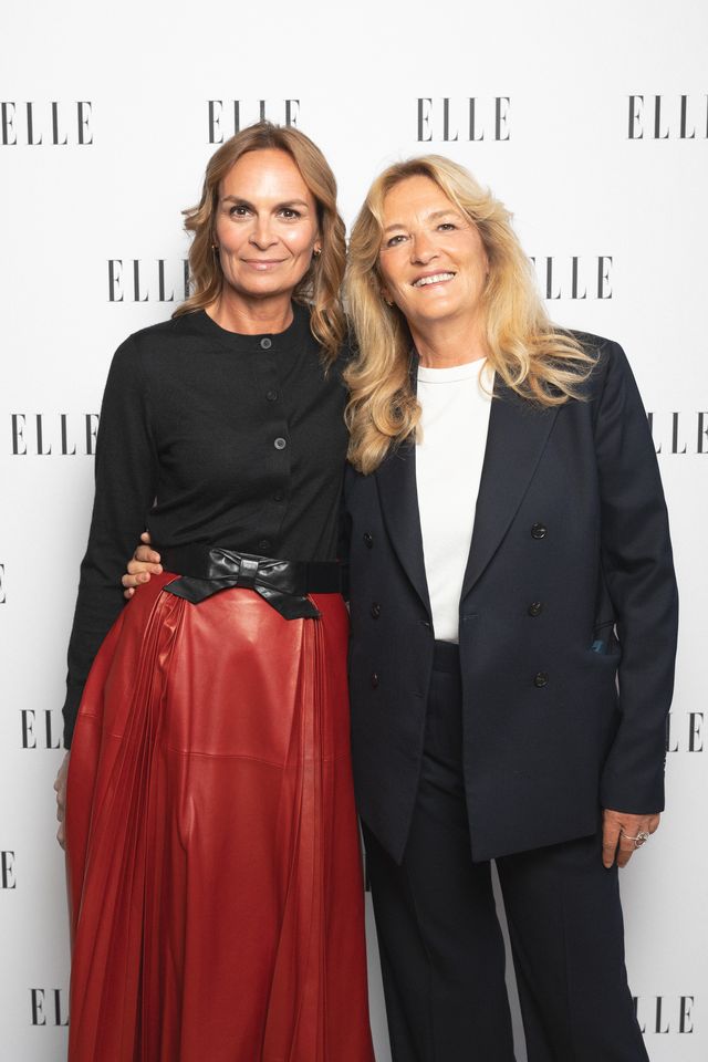 Vanessa Bruno et Véronique Philipponnat (ELLE) posent amicalement l’une à côté de l’autre. Vanessa Bruno est vêtue d’un chemisier lavande et d’un jean, tandis que Véronique Philipponnat porte une chemise blanche, une jupe plissée noire et une veste noire posée sur les épaules.