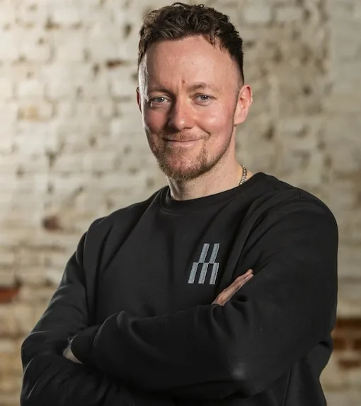 Portrait de Matthias Meiss devant un mur de briques