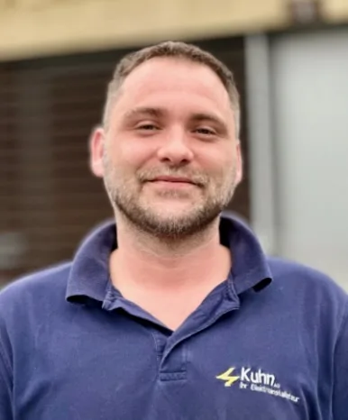 Deux employés de Kuhn AG devant le véhicule de l'entreprise avec le logo Kuhn