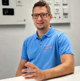 Daniel Büsser sonriendo en un retrato, con polo azul