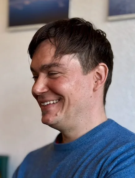 Retrato de Florian Bruch sonriendo en un interior