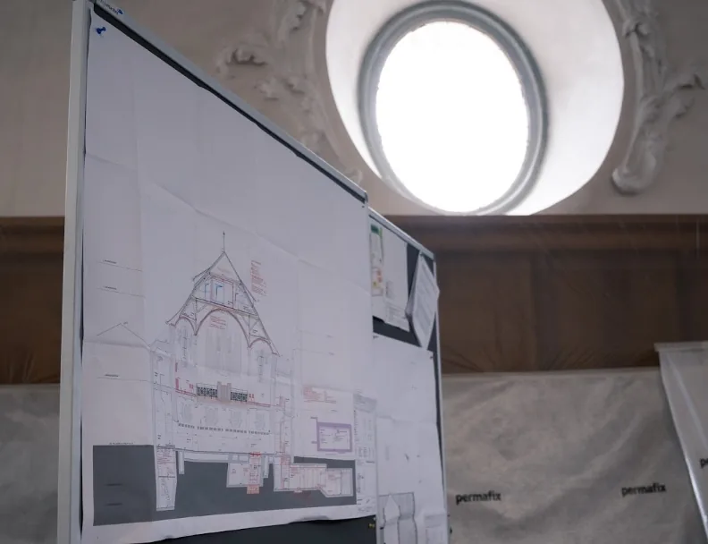 Planos de construcción en un panel frente a una ventana de la iglesia de San Pedro