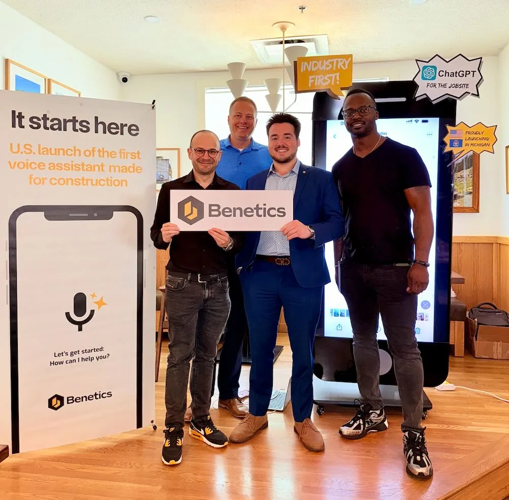 Four men holding a Benetics sign next to the 'It starts here' U.S. launch banner