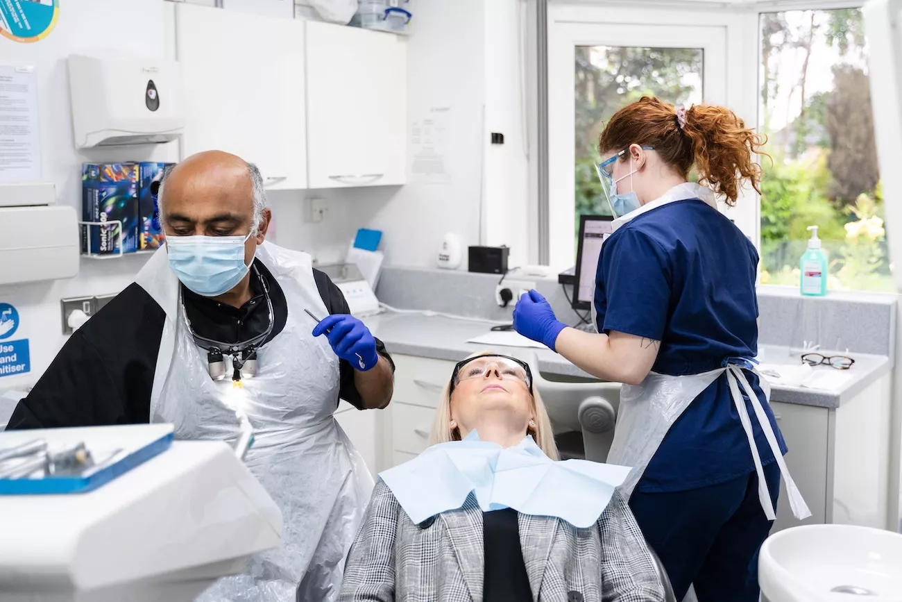 A dentist and dental nurse treating a female patient at Kingfisher Dental Practice in Redditch