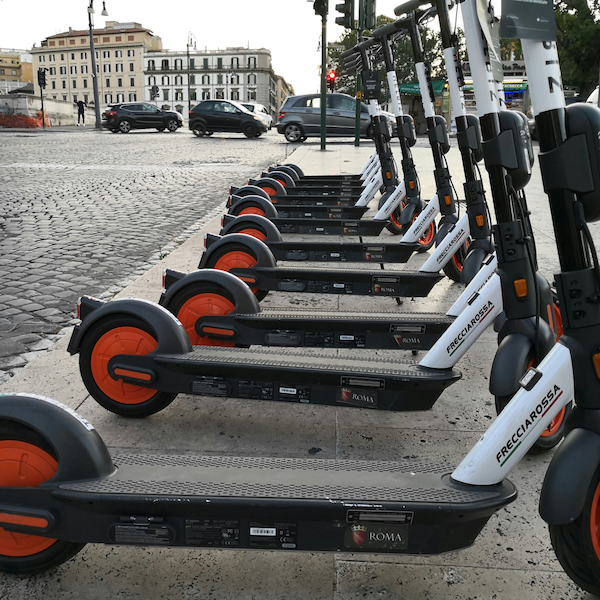 A line of rentable electric scooters in a European capital city.