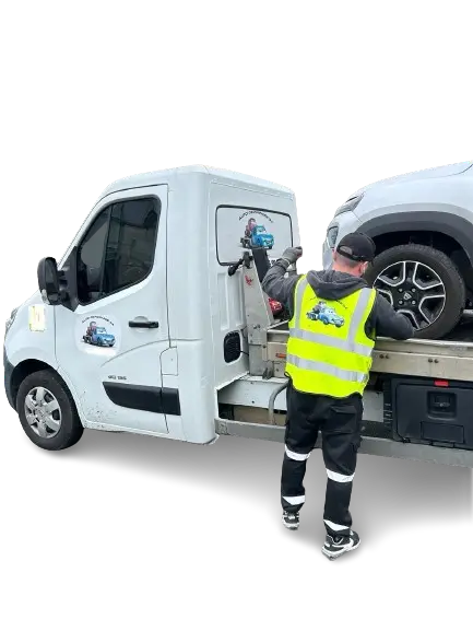 Dépanneur chargeant un véhicule sur une dépanneuse blanche.