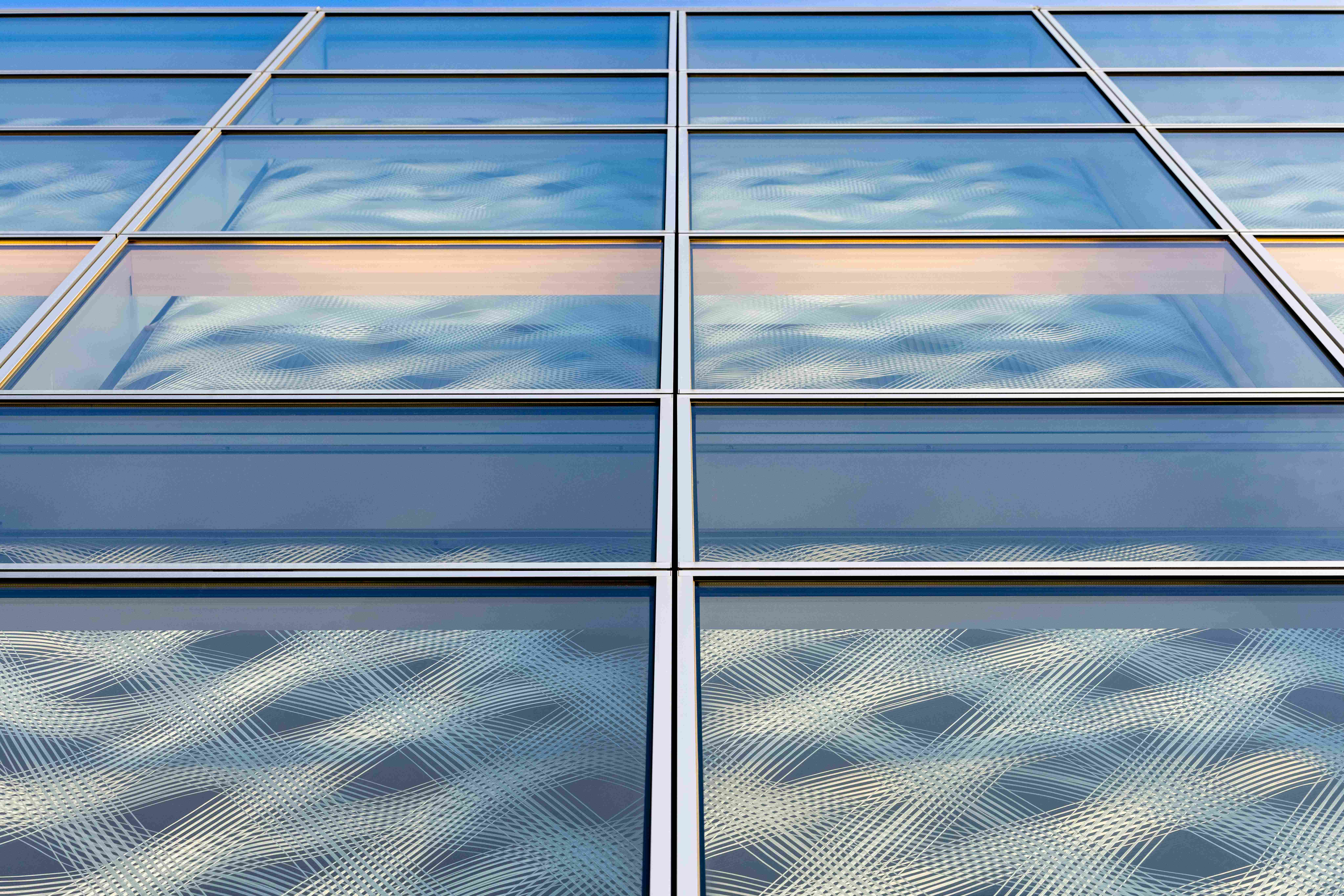 i-Mesh textile façade panels showing modular grid and light diffusion behind glass