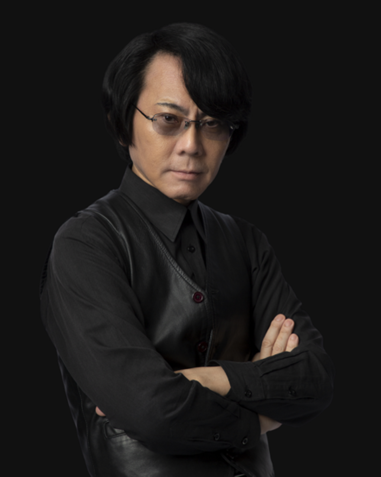 Ritratto di Hiroshi Ishiguro con le braccia conserte, in abito nero su sfondo scuro, associato al padiglione Future of Life all'Expo 2025 di Osaka