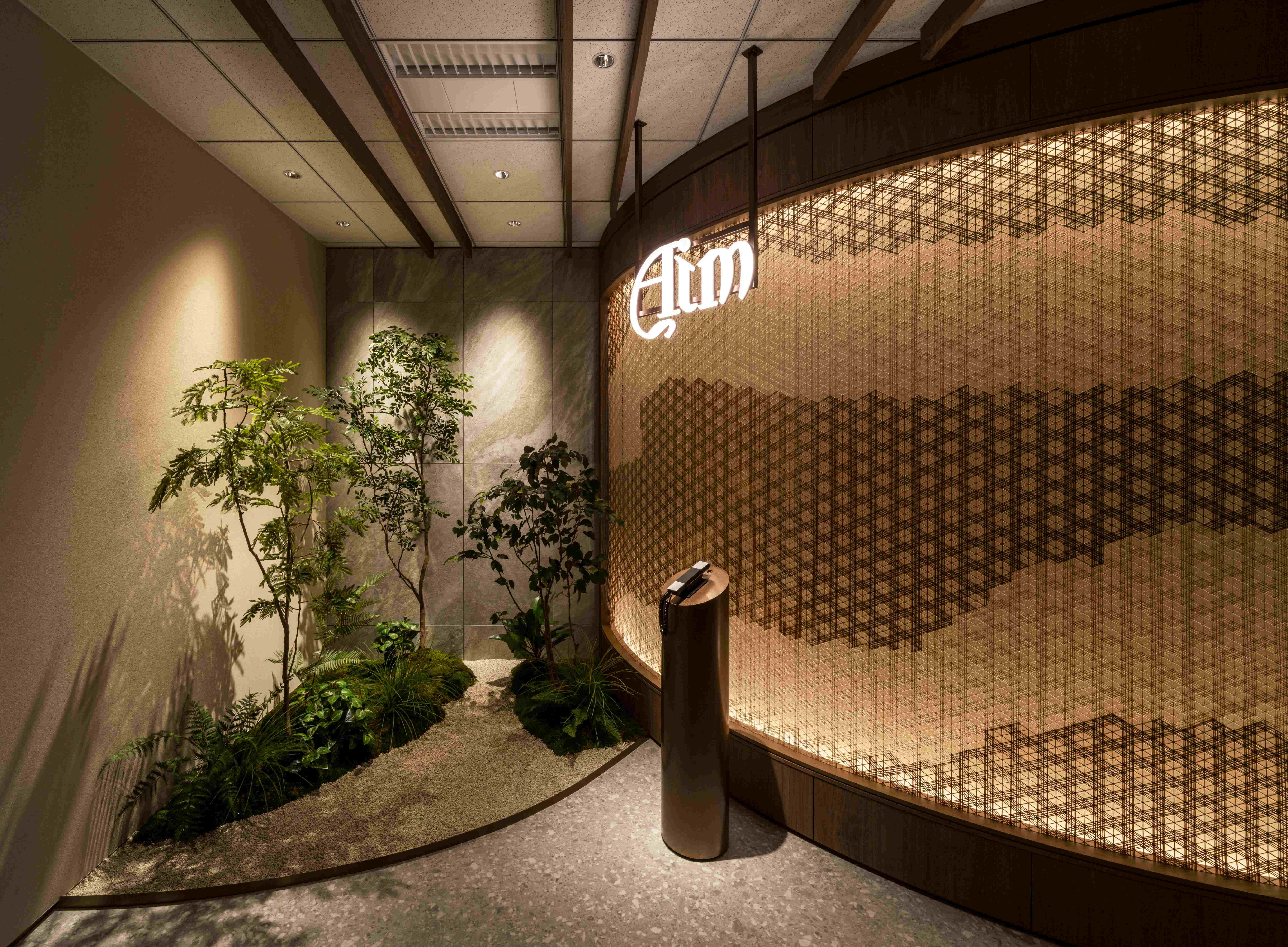 Office Marunouchi entrance area with interior garden and illuminated i-Mesh Kumiko wall