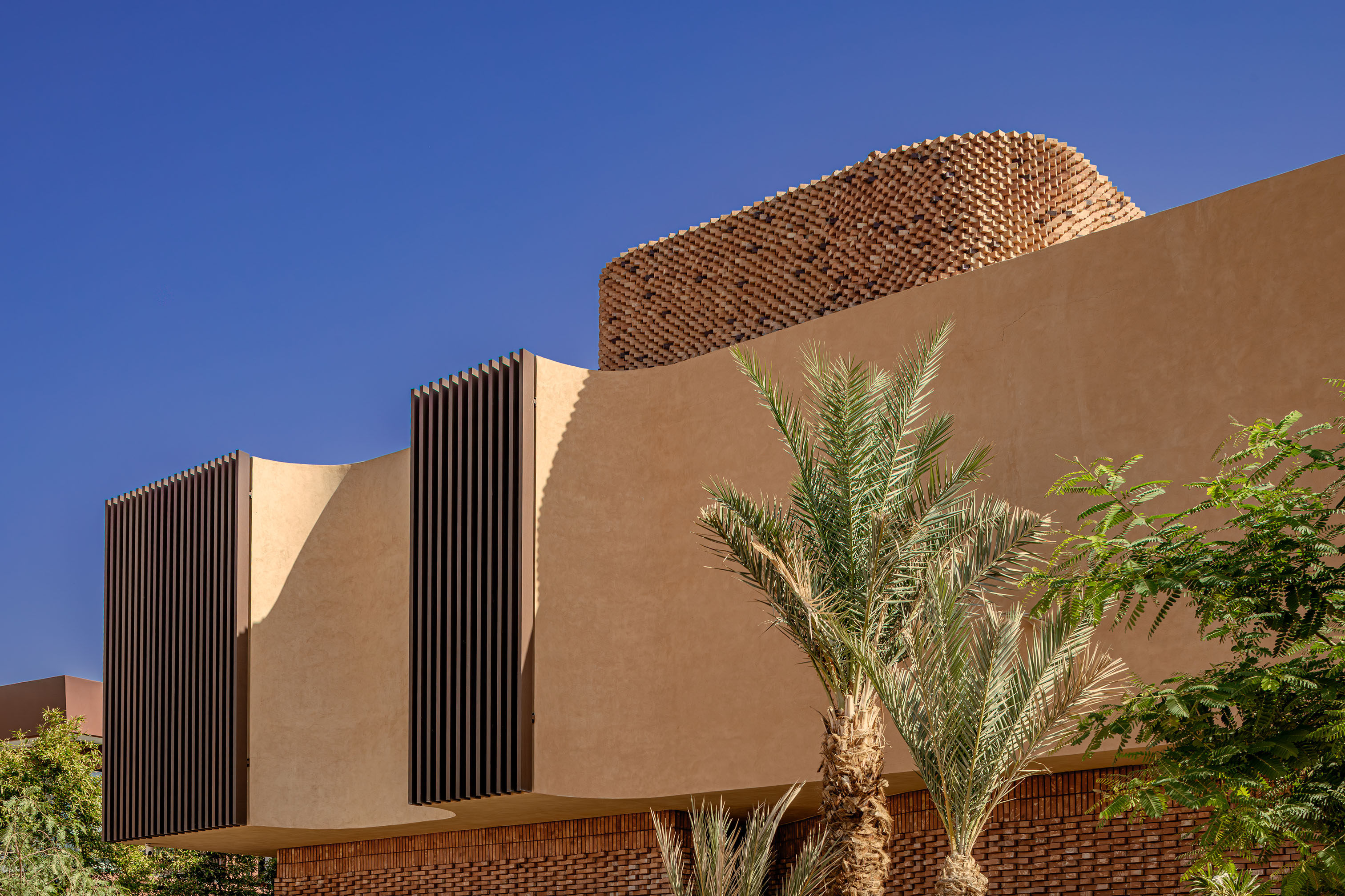 Villa Vol.005 by Studio BO - rammed-earth facade with vertical wood brise-soleil louvers