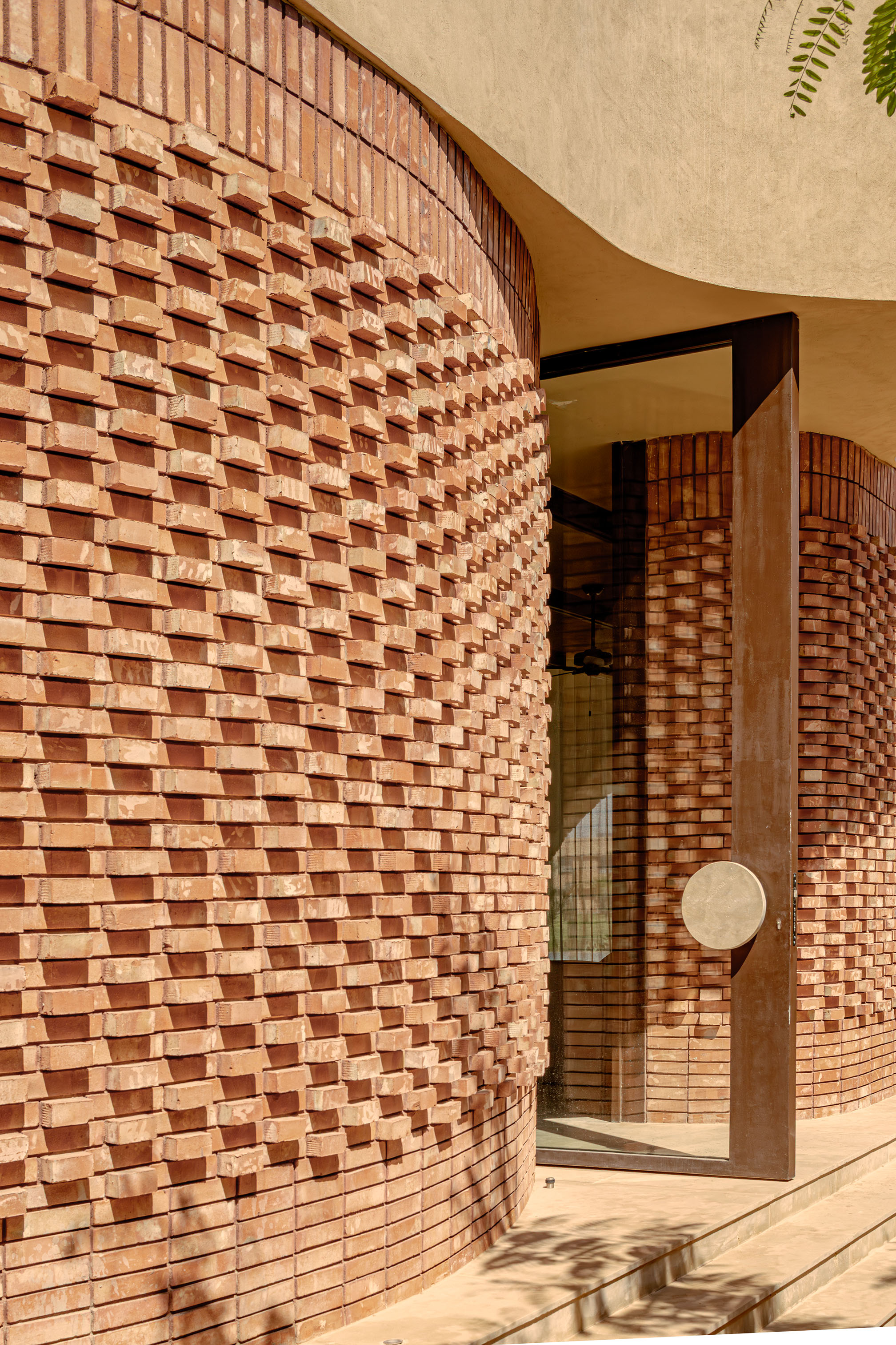 Villa Vol.005 by Studio BO - textured brick wall detail with pivoting entrance door