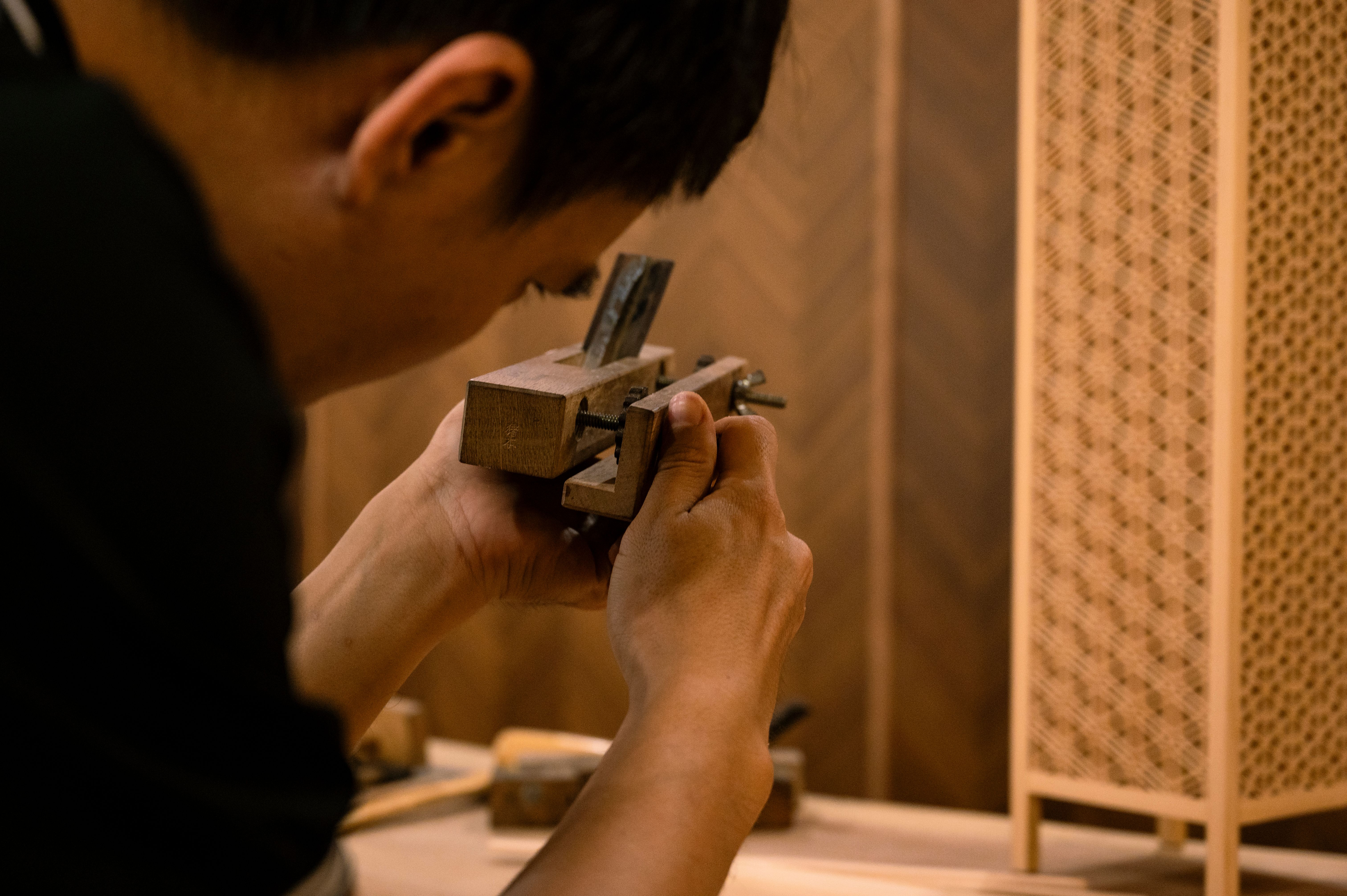 Artigiano al lavoro su un utensile in legno, lavorazione artigianale con tecnica tradizionale