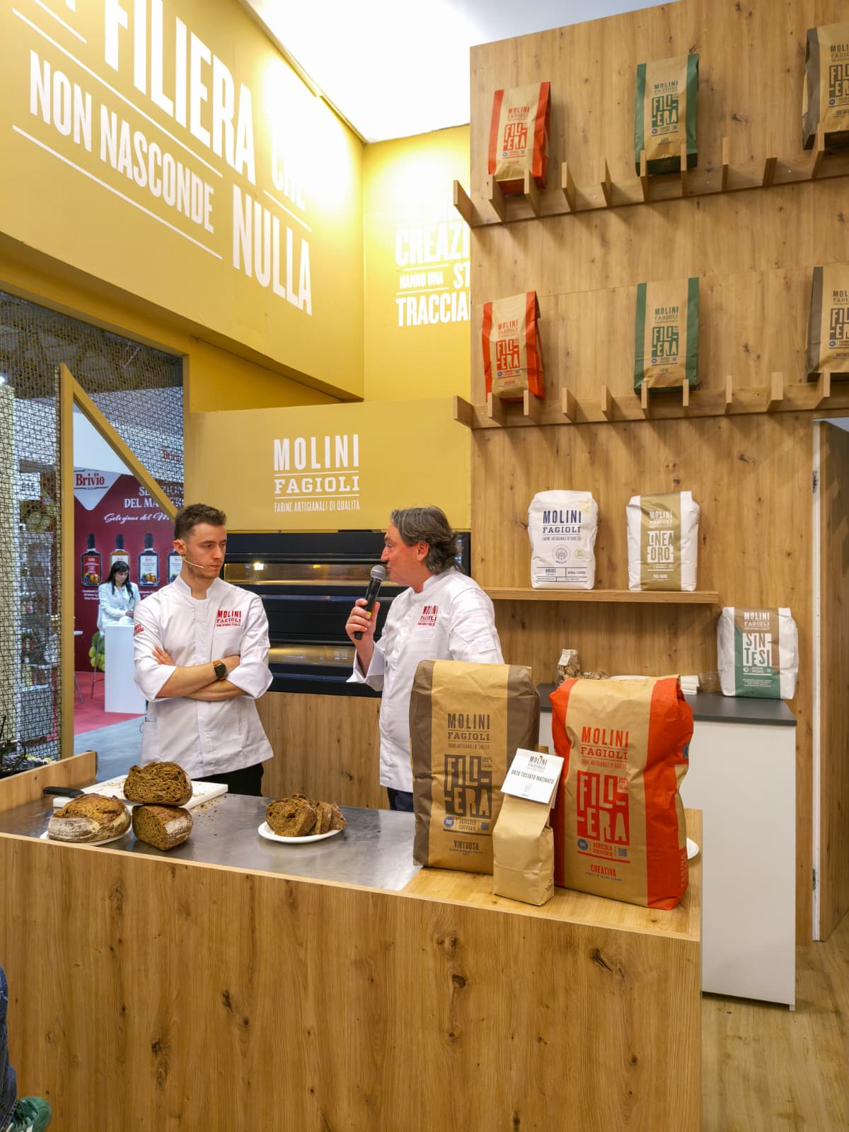 Bakery interior of the Molini Fagioli stand with bakers and Filiera flour on display