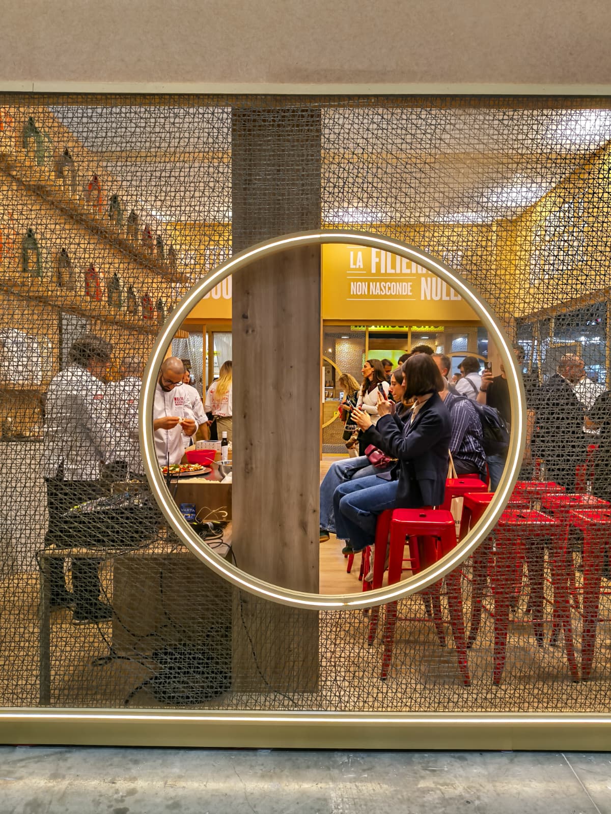 Detail of the circular i-Mesh window revealing the interior of the Molini Fagioli stand