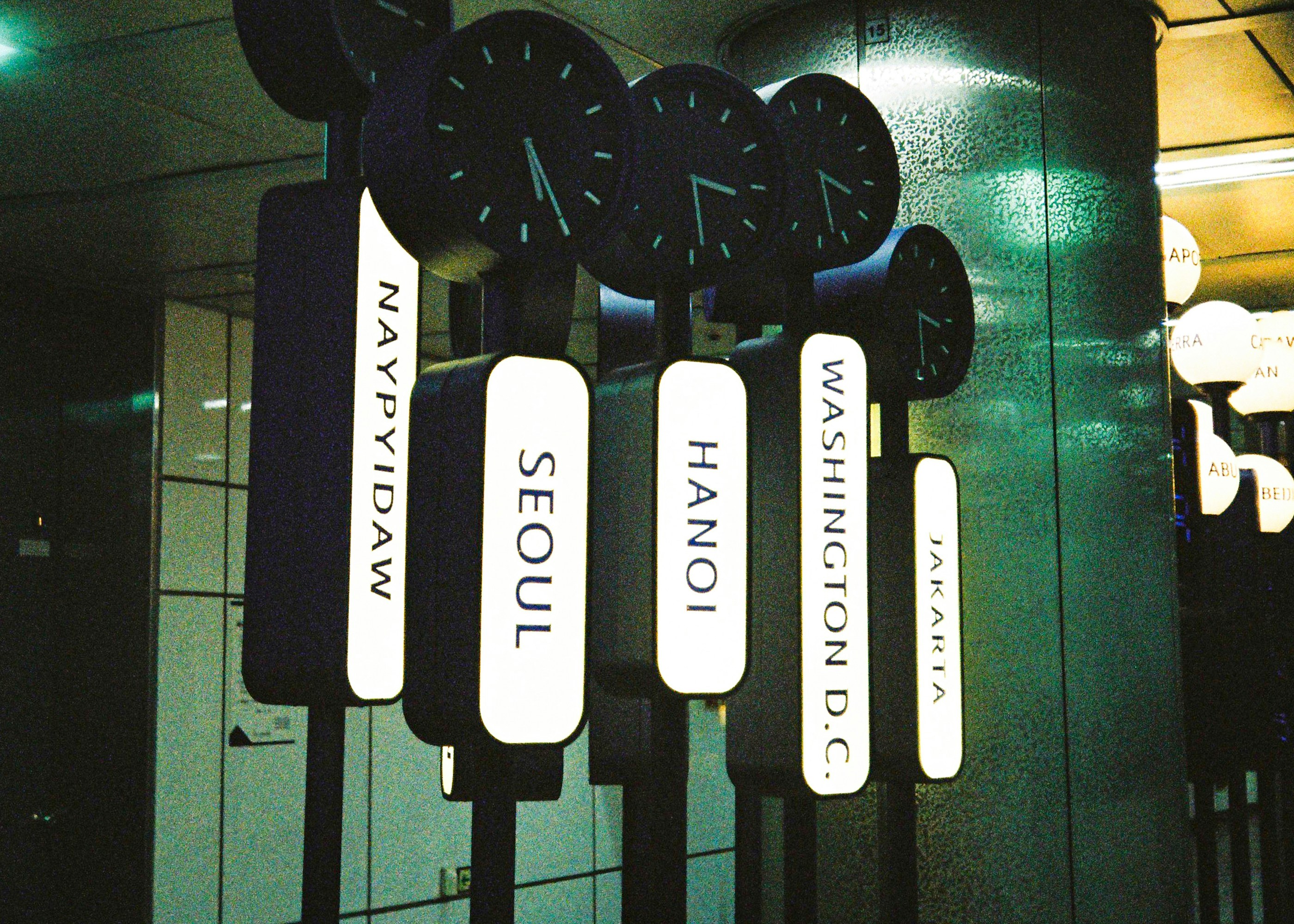 Airport-style world clocks showing global time zones across major cities, including Jakarta, Washington D.C., Hanoi, Seoul, and Naypyidaw.